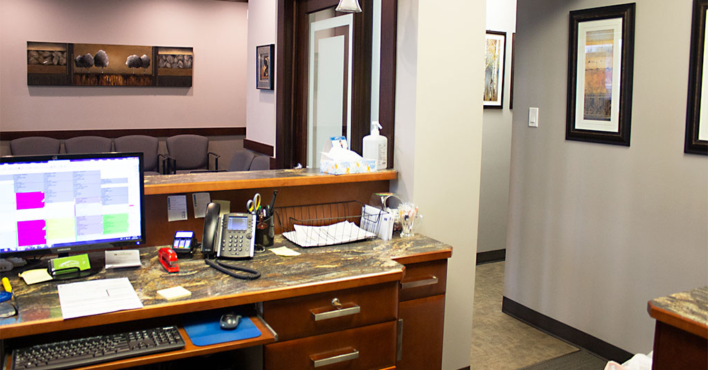 Front desk team member working at the Hill Top Dental Group reception desk