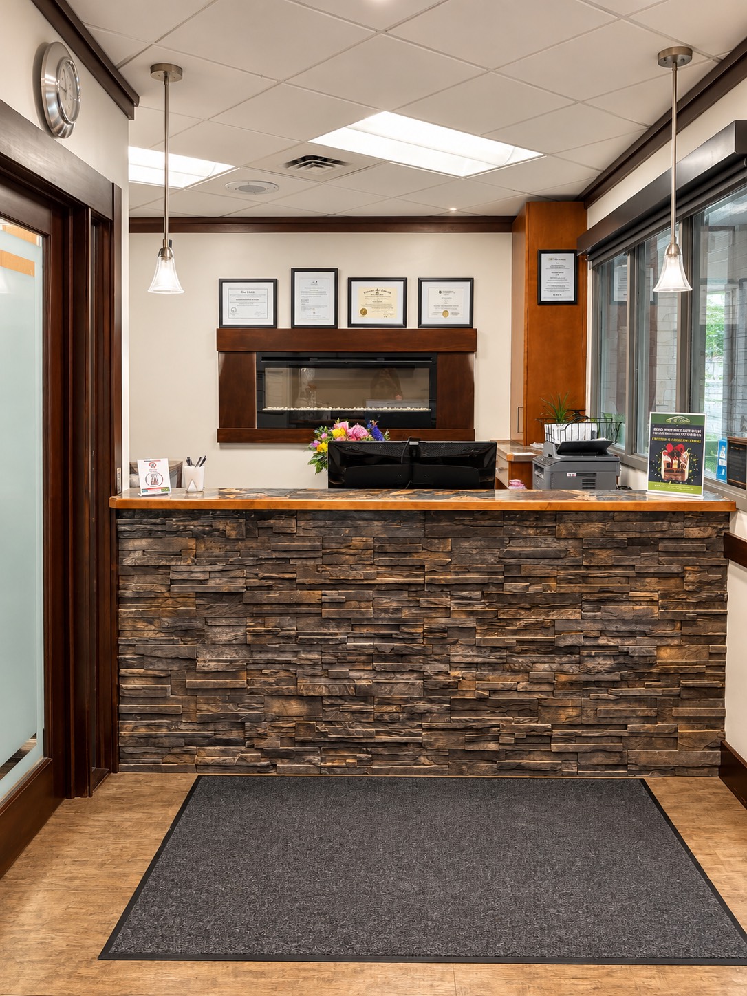 Reception desk with framed diplomas and fresh flowers at Hill Top Dental Group in Prince Albert